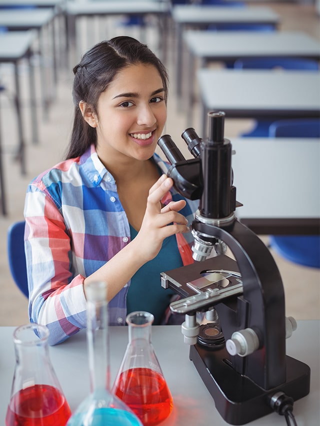 portrait schoolgirl experimenting microscope laboratory