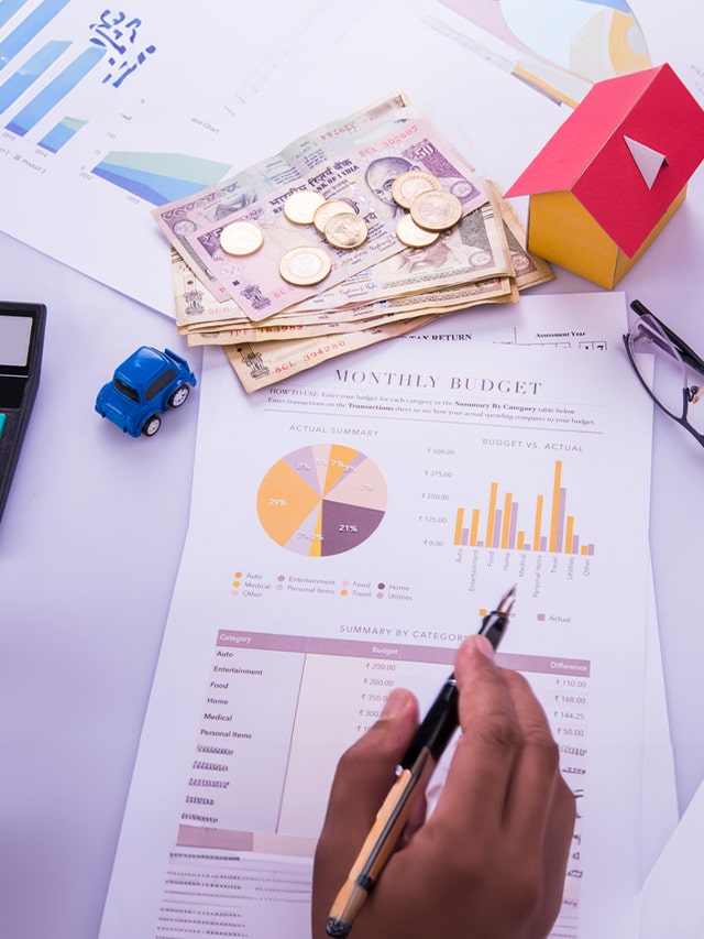poster-Indian accountant working on Income tax forms or on budget planning with currency notes; accountant hiring, recruitment concept