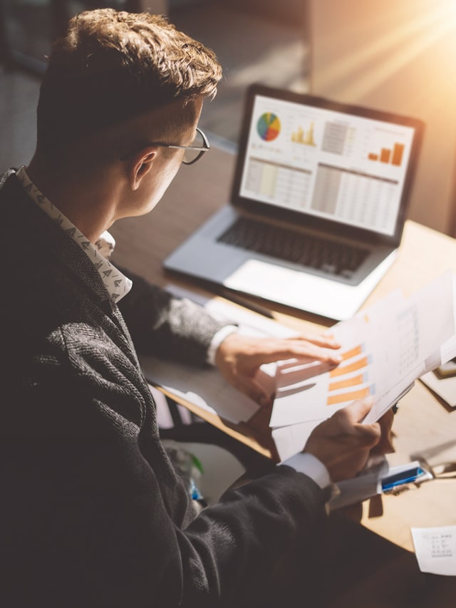 poster-Businessman analyses document in his hands; business analyst hiring; recruitment concept.