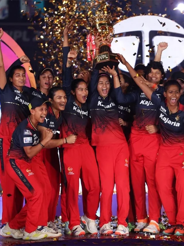 WPL RCB team holding celebrating win and holding wpl 2024 trophy.