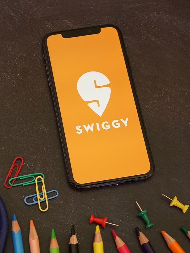 Swiggy App with Colored Pencils and Blue Scissor. Swiggy is an online food ordering and delivery platform; concept of swiggy data science internship