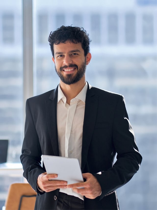 Happy professional holding digital tablet standing in office, vertical portrait. Concept of Top Companies Hiring Business development Manager