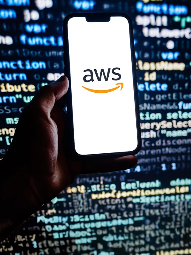 AWS written on a mobile screen, with coding background; concept of Most Asked AWS Interview Questions and Answers in 2024