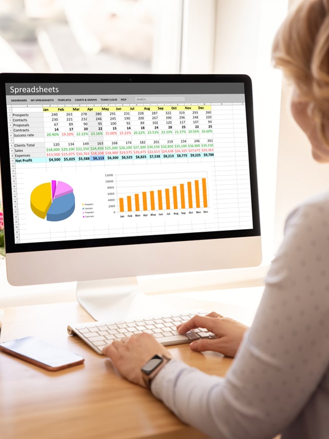 Woman working with spreadsheets on desktop computer; concept of top companies actively hiring data analysts in mid-June 2024.