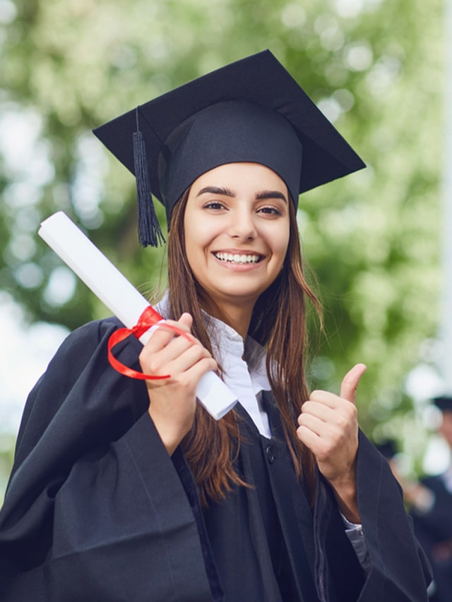 A young female BCA student holding graduate degree against the background of university graduates.; concept of High-paying jobs after BCA