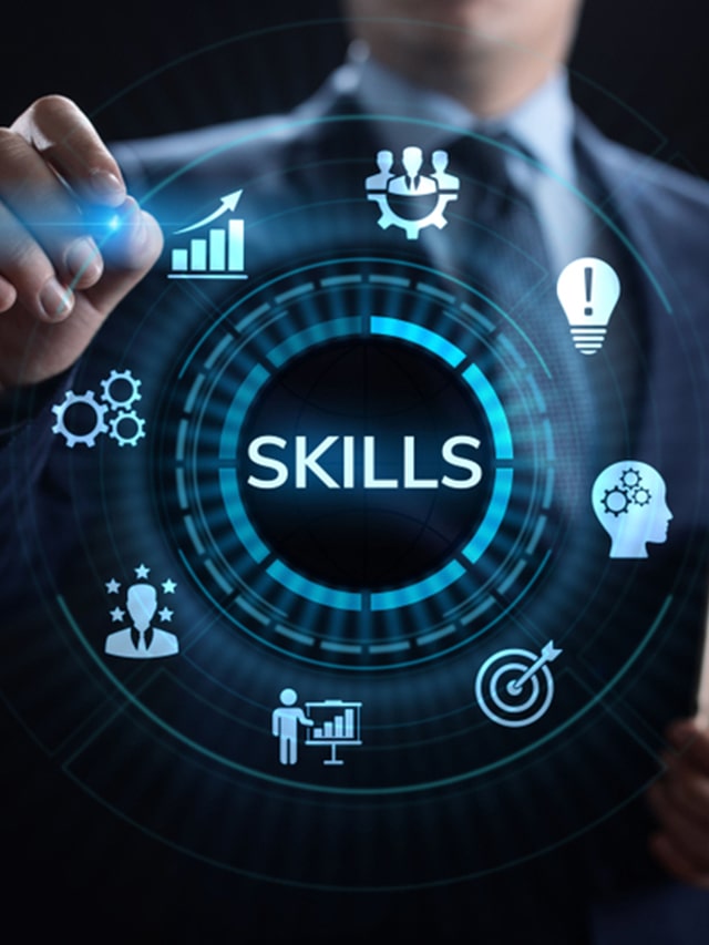 Man wearing Navy Blue suit holding a tablet in hand standing on dark background pointing virtually at Skills Education Learning Personal development; concept of Top 5 Skills Google Considers Before Hiring