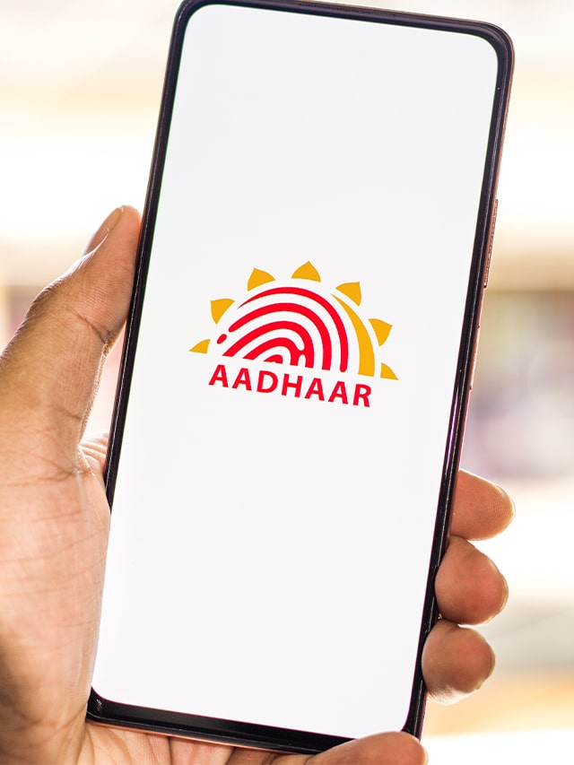 Aadhaar logo on phone screen. man holding smartphone; concept of Aadhar UIDAI Internship 2024 Full Details