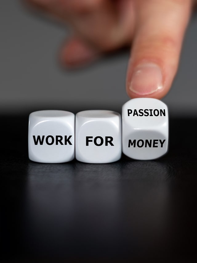 Hand turns dice and changes the expression 'work for money' to 'work for passion; concept of Salary vs. Benefits: The Job Seeker's Dilemma