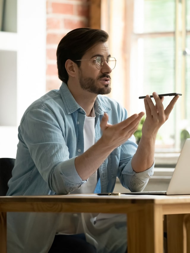 Man sitting at office desk requesting sudden leave with laptop holds mobile in hand; How to Request Sudden Leave Professionally: 7 Easy Tips