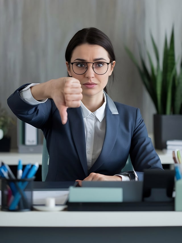 Businesswomen showing thumbs down sign over grey background; concept of Common Freshers Interview Mistakes and How to Avoid Them