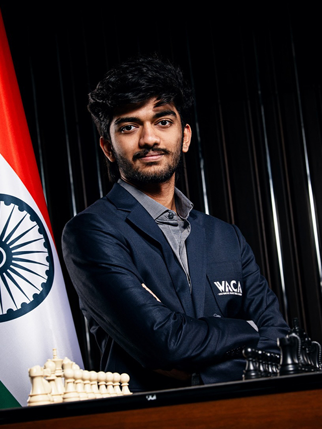 photo of chess grandmaster 2024 D gukesh with folded hoands and a india national flag